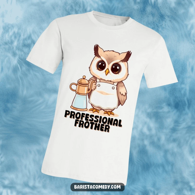 Funny cute owl adorning a tiny apron, expertly frothing milk with a steamer, printed on a t-shirt for coffee lovers.
